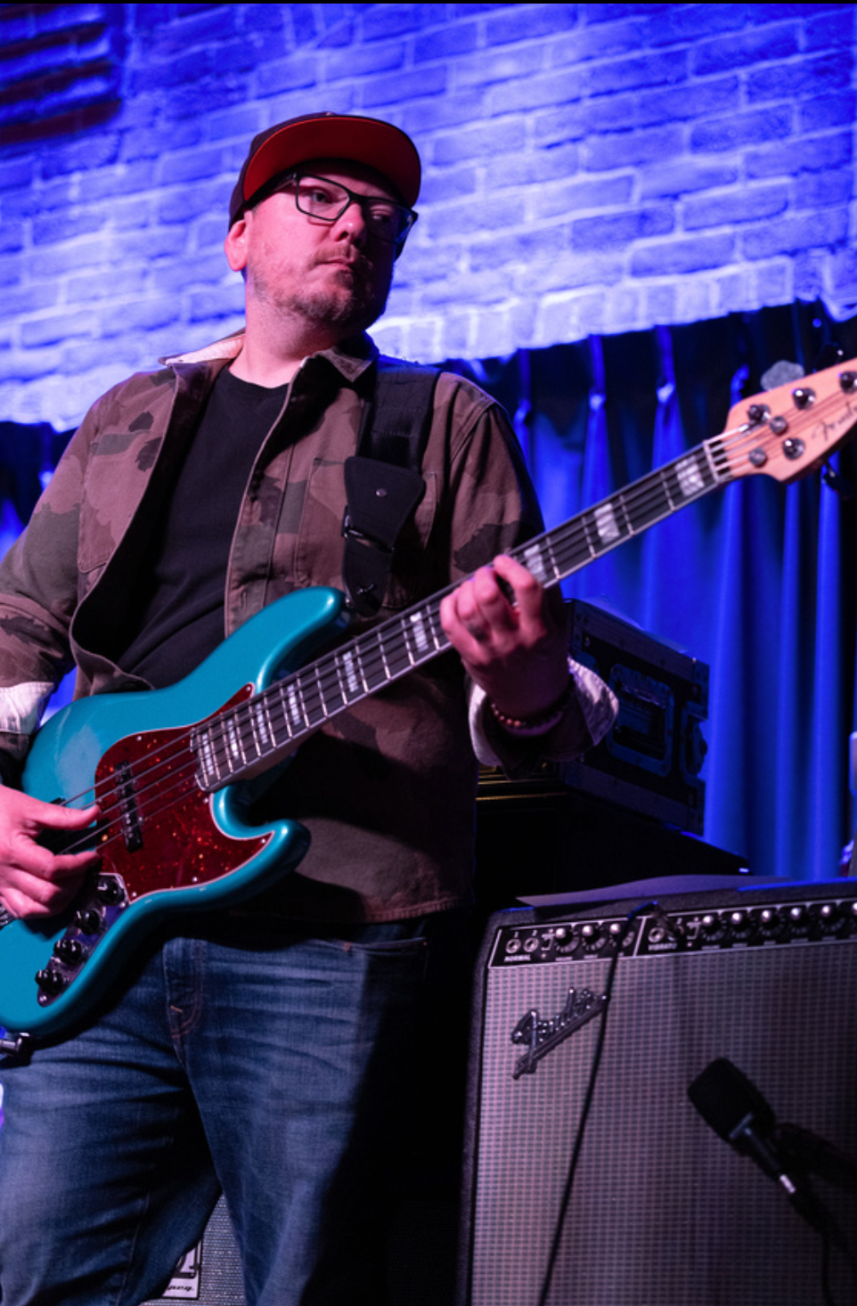 Bassist on a blue Fender Jazz bass