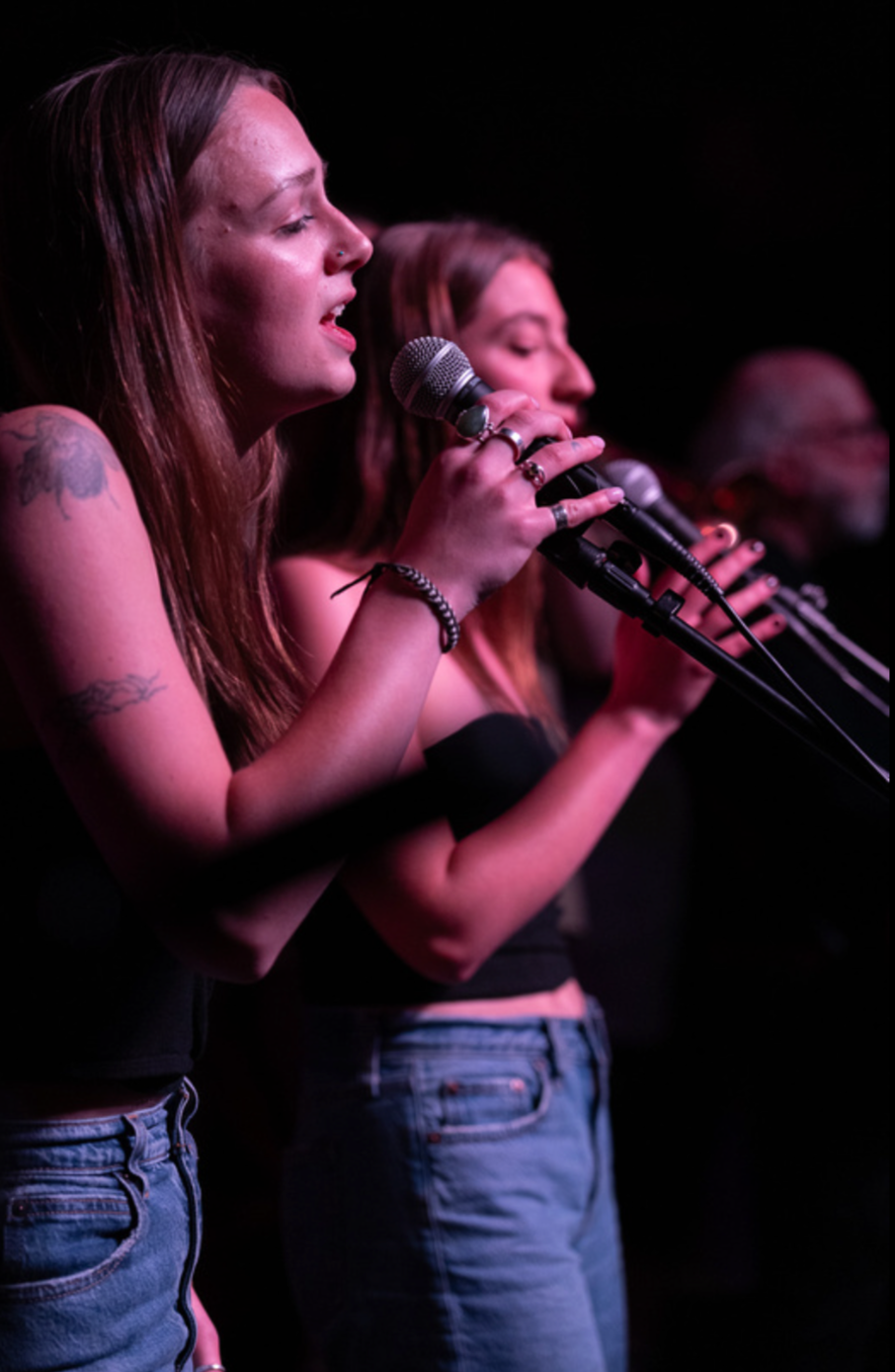 Vocalists under pink stage lights
