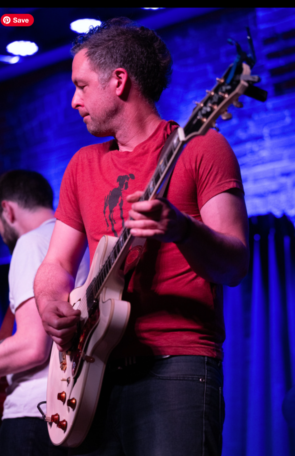 Guitarist in a red shirt on a white hollow-body